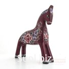 A dark red horse with a bouquet of violets on its sides